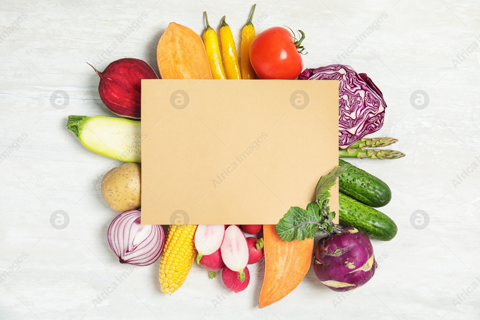 Photo of Flat lay composition with fresh vegetables and blank card for text on light background