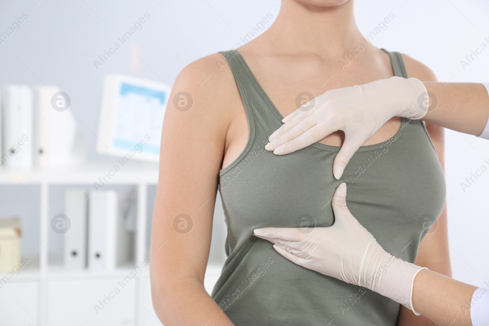 Photo of Doctor checking woman's breast at hospital, closeup