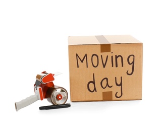 Photo of Moving box, marker and adhesive tape dispenser on white background