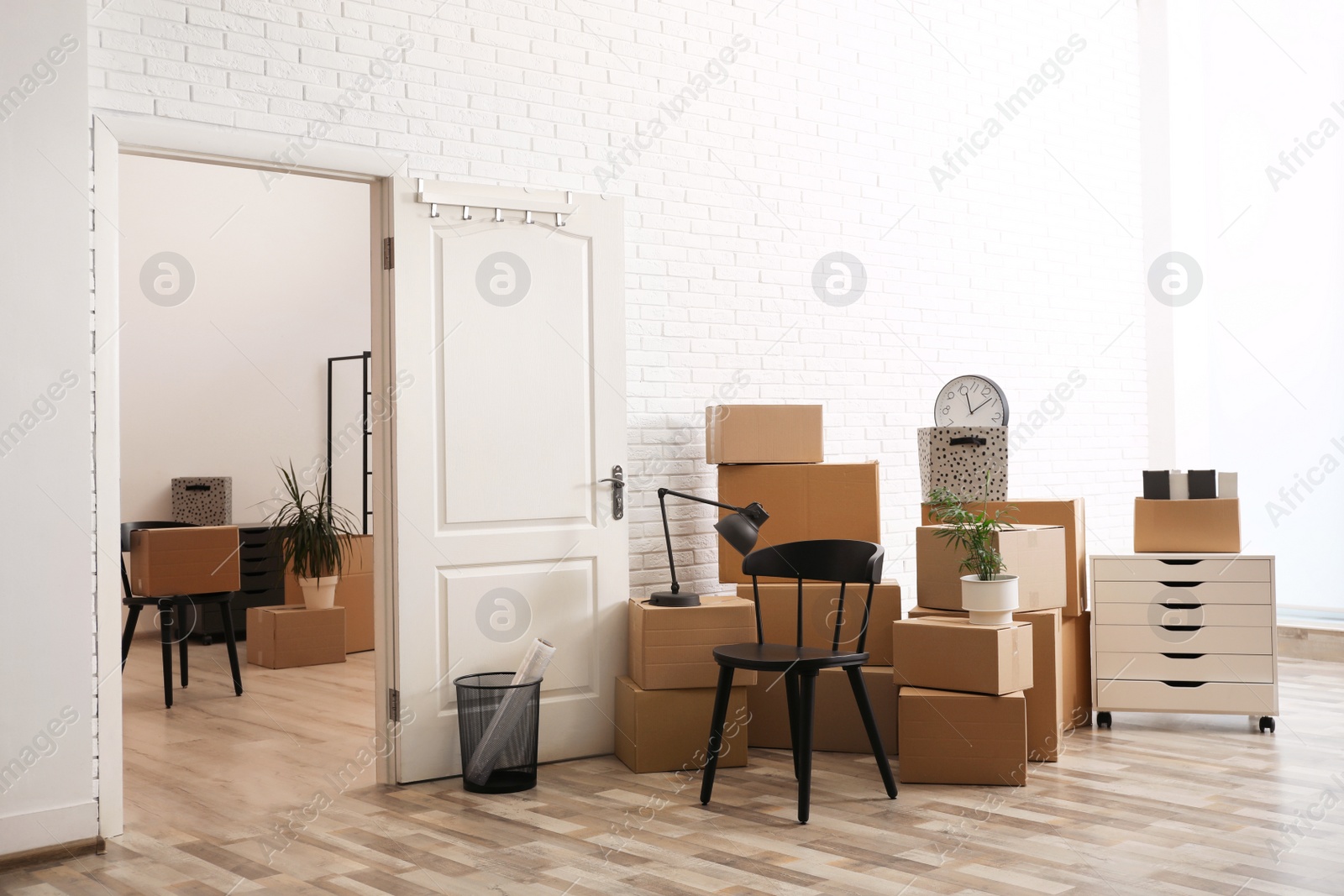 Photo of Cardboard boxes and furniture in new office. Moving day