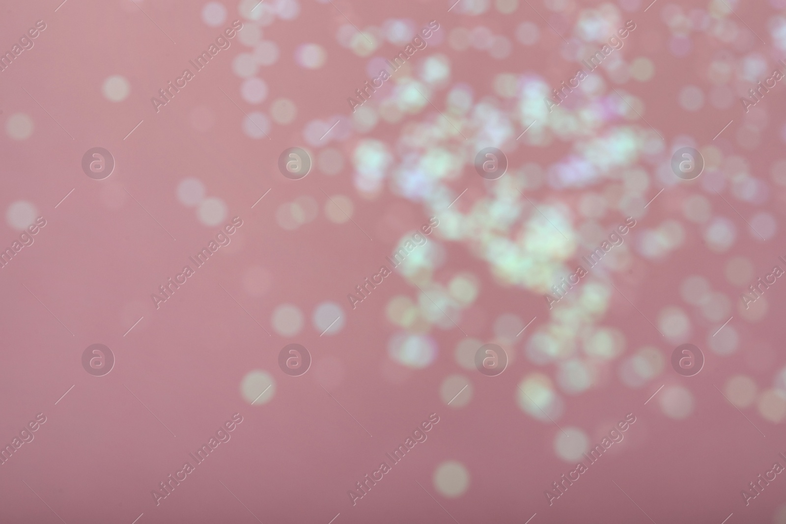 Photo of Blurred view of white glitter on pink background. Bokeh effect