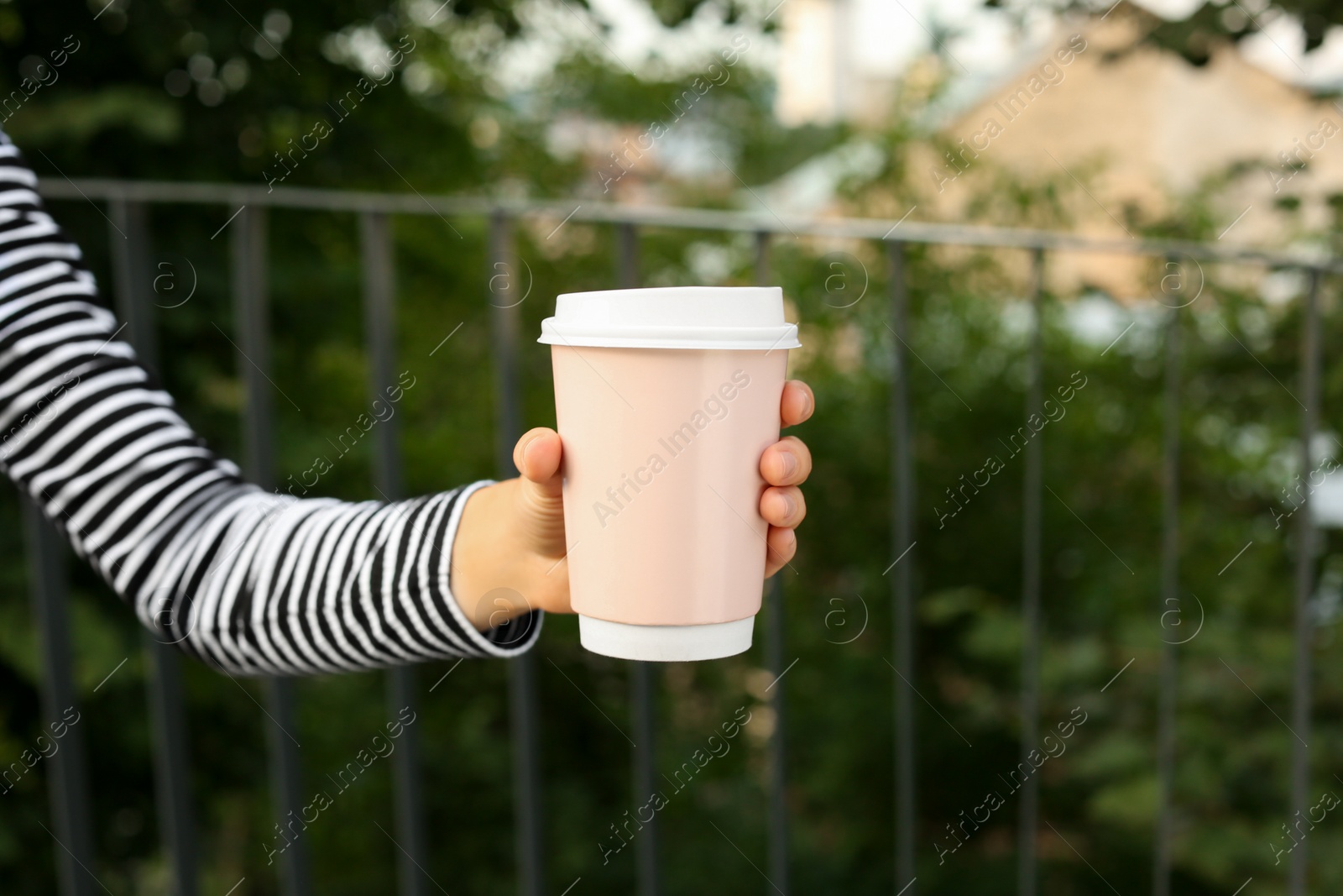 Photo of Coffee to go. Woman with paper cup of drink outdoors, closeup. Space for text