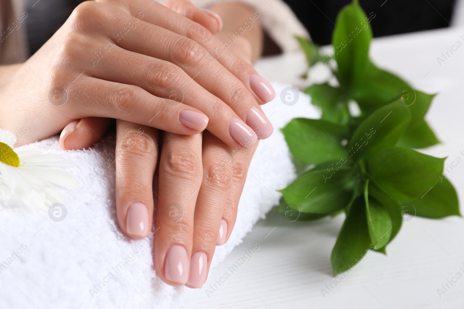 Photo of Closeup view of woman with beautiful hands at table. Spa treatment