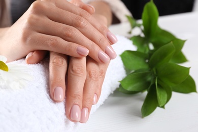 Photo of Closeup view of woman with beautiful hands at table. Spa treatment