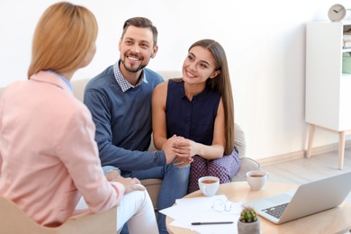 Photo of Female real estate agent working with couple in office