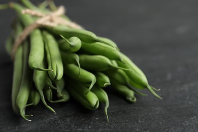 Photo of Fresh green beans on black table, closeup