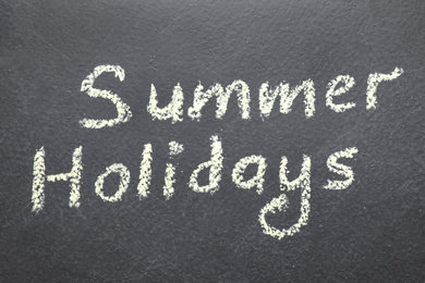 Photo of Phrase SUMMER HOLIDAYS written on black background. School's out