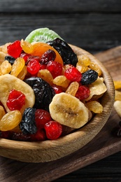 Photo of Bowl with different dried fruits on wooden background. Healthy lifestyle