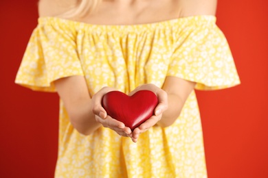 Photo of Woman with decorative heart on color background, closeup