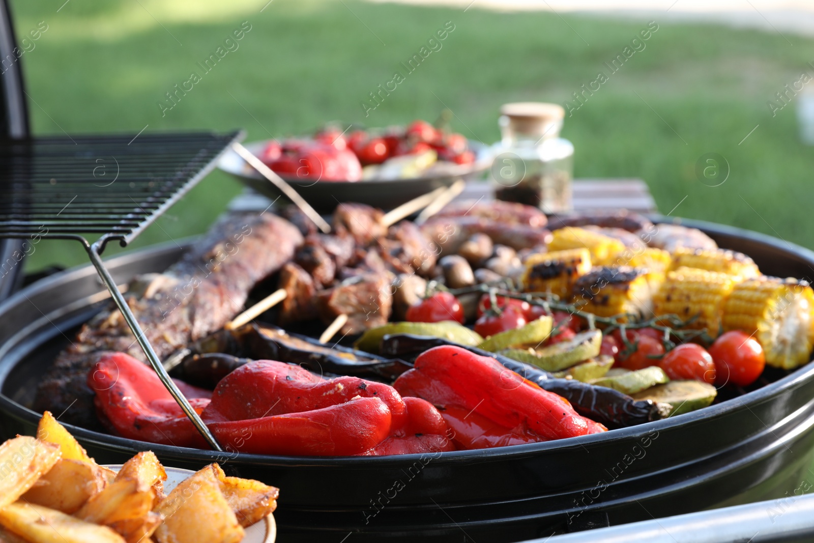 Photo of Tasty meat and vegetables on barbecue grill outdoors, closeup