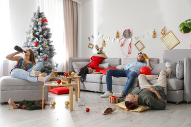 Photo of Drunk friends in messy room after New Year party