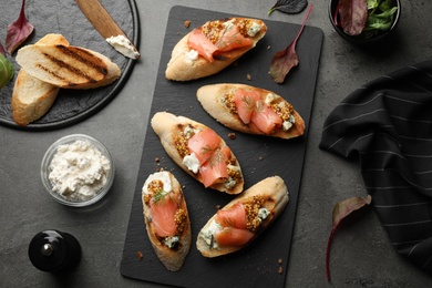 Photo of Flat lay composition with tasty bruschettas on grey table