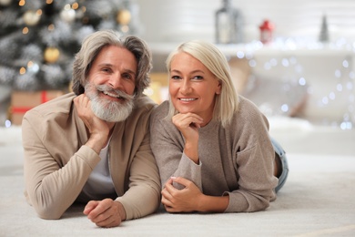 Happy couple lying on floor at home. Christmas eve