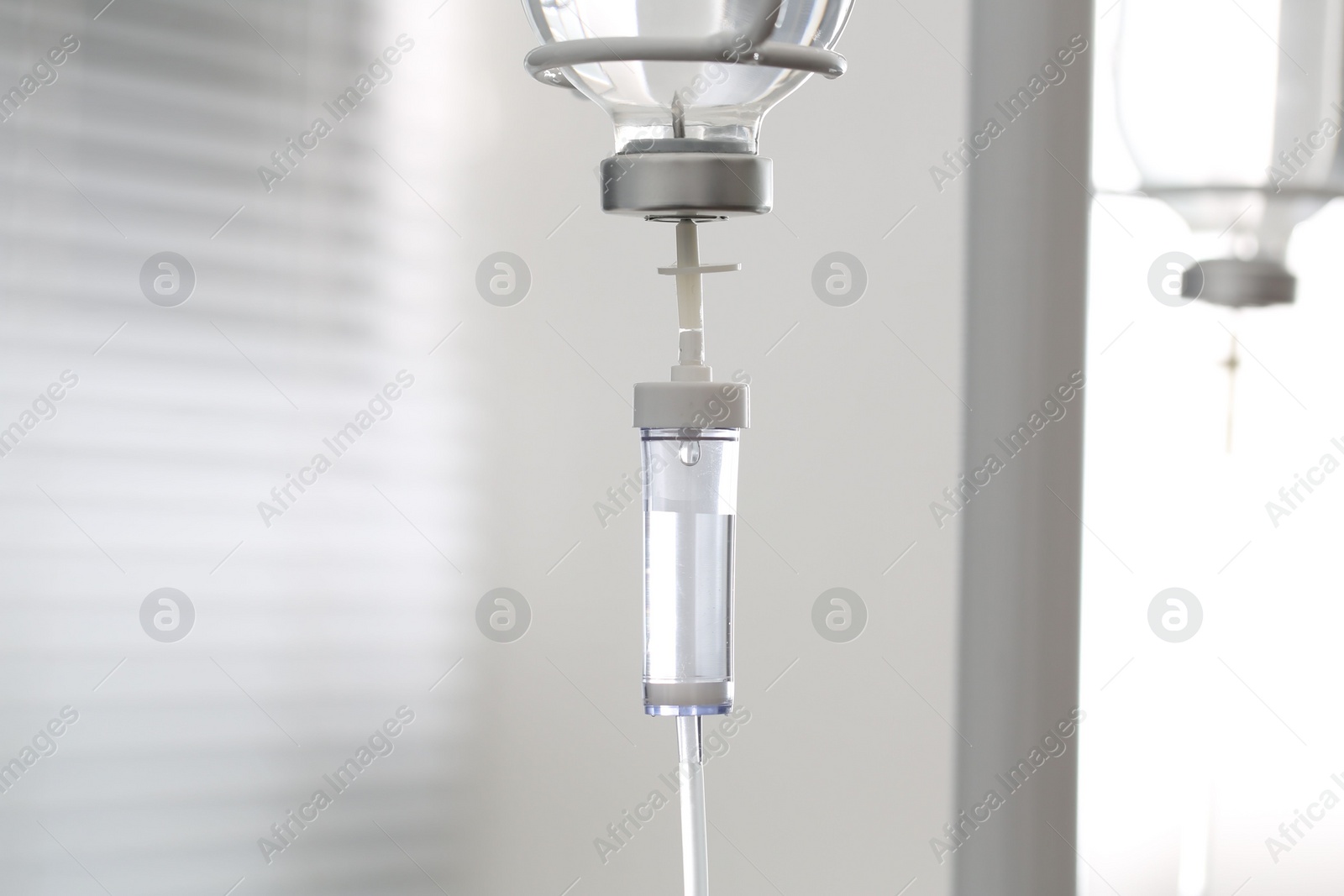 Photo of IV drip chamber against blurred light background