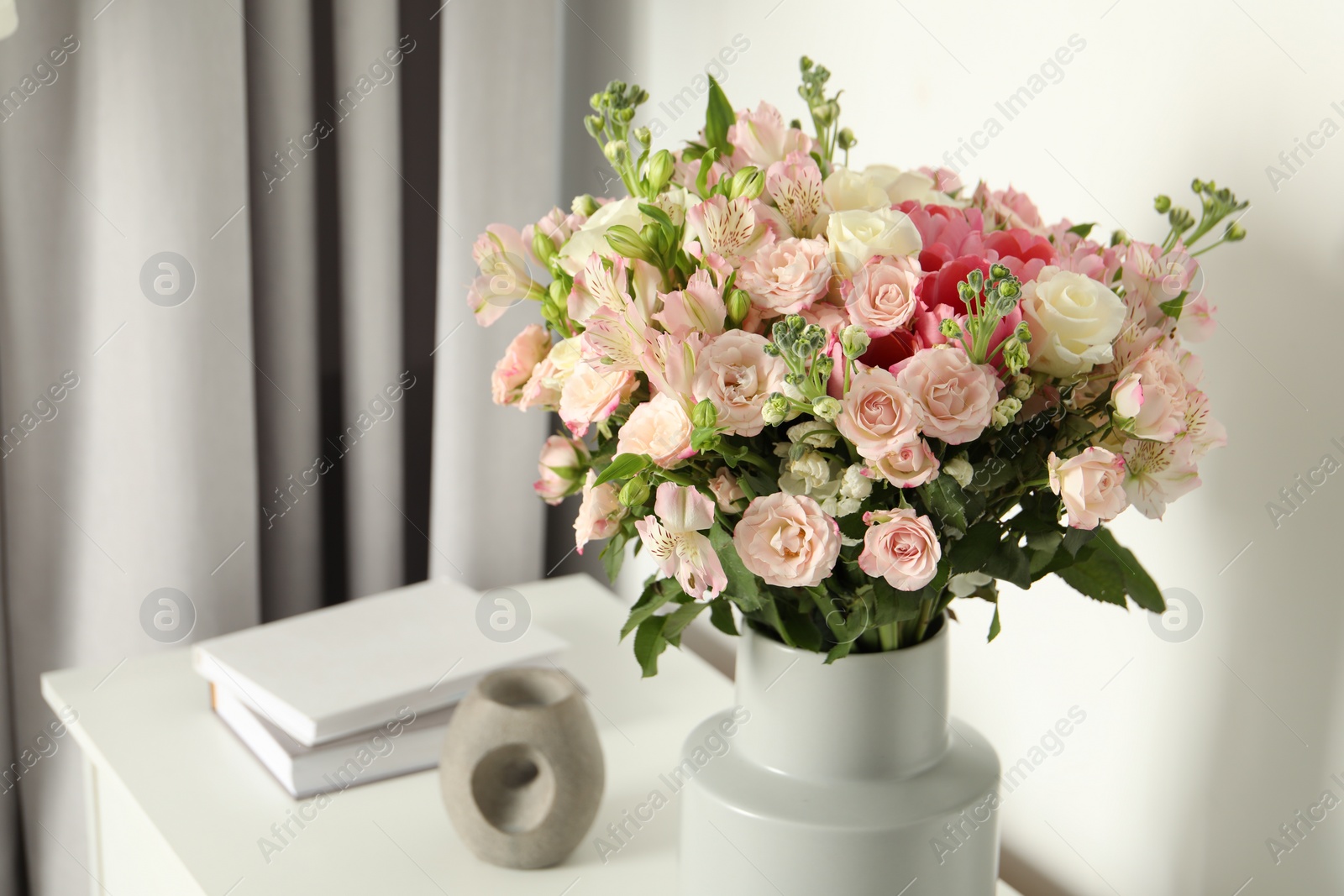 Photo of Beautiful bouquet of fresh flowers in vase on white table indoors, space for text