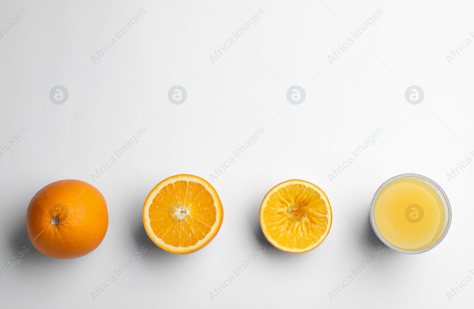 Photo of Fresh and squeezed oranges with juice in glass on white background, top view