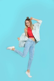 Full length portrait of emotional woman dancing on color background