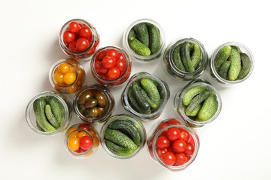 Pickling jars with fresh vegetables on white background, top view