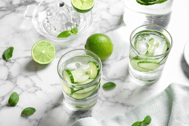 Photo of Glasses with fresh cucumber water on table