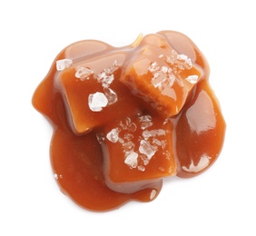 Caramel candies under tasty sauce with salt isolated on white, top view