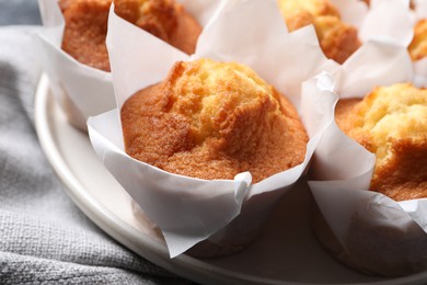 Photo of Delicious sweet muffins on grey fabric, closeup