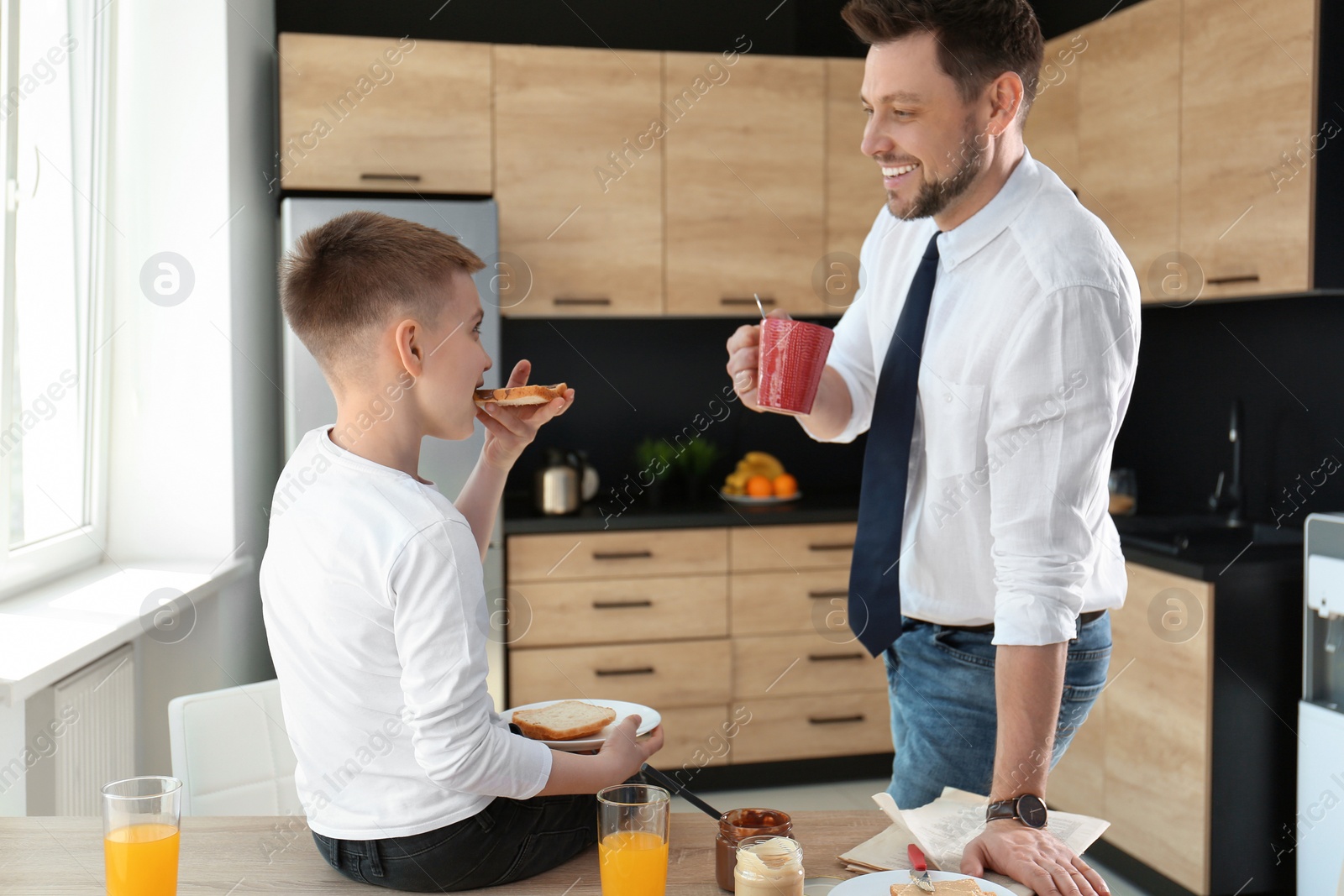 Photo of Dad and son having breakfast together in kitchen