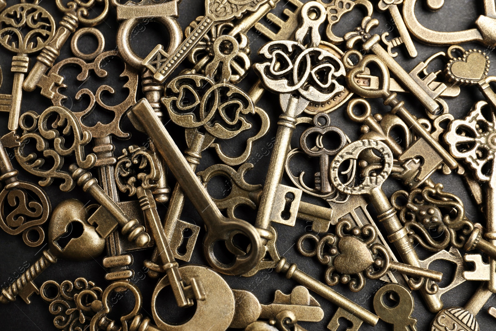 Photo of Bronze vintage ornate keys on dark background, top view