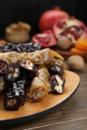 Many delicious sweet churchkhelas on wooden table, closeup