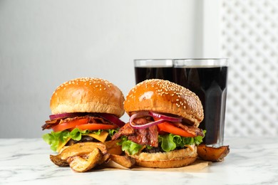 Photo of Tasty burgers, potato wedges and refreshing drink on white marble table. Fast food
