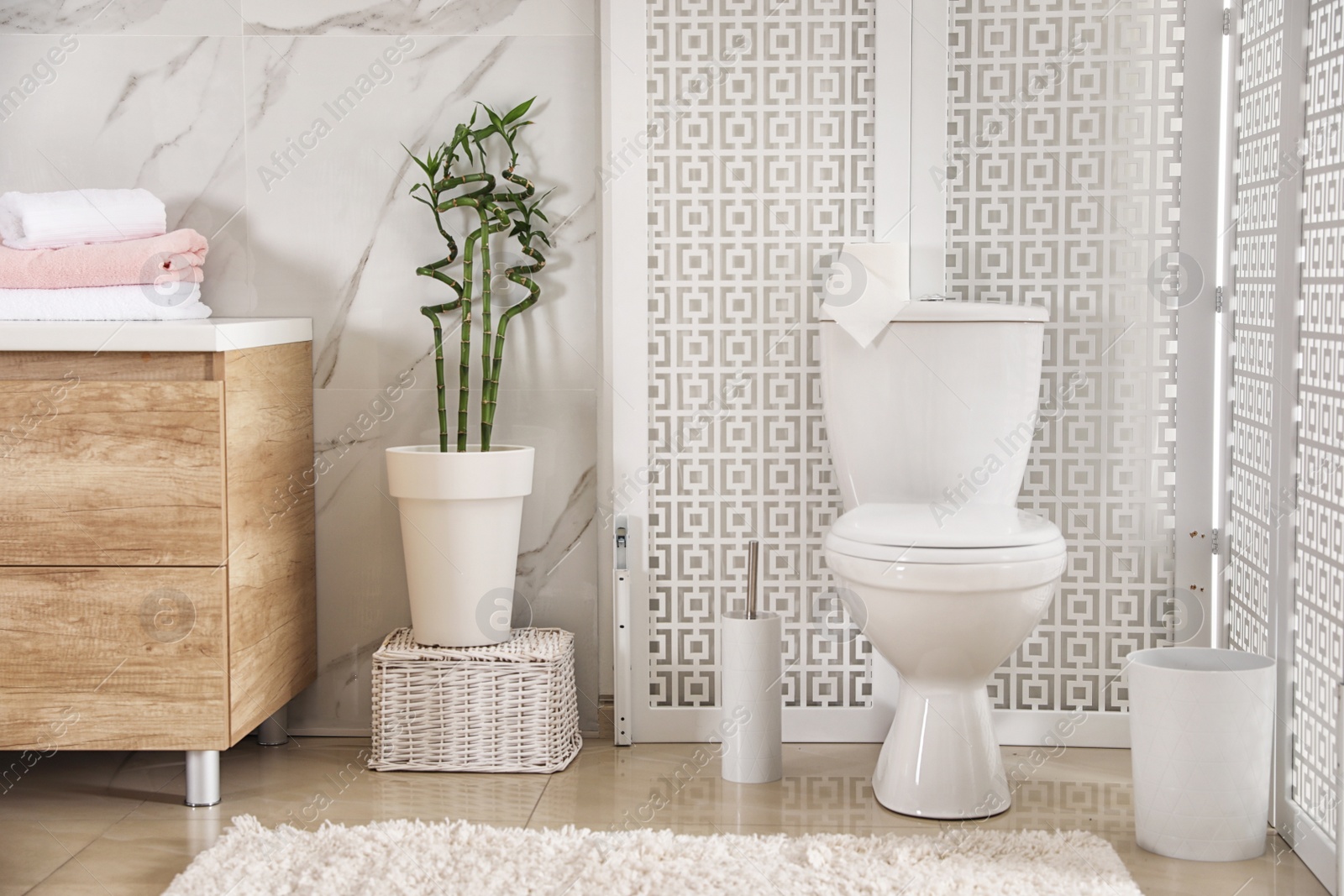 Photo of Modern toilet bowl with roll of paper in bathroom