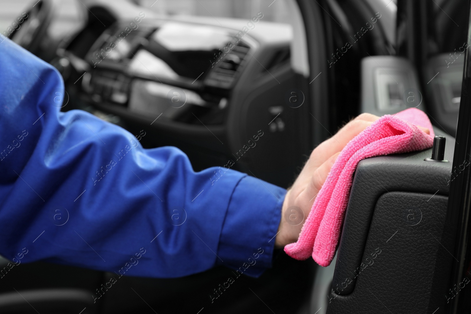 Photo of Car wash worker cleaning automobile interior, closeup