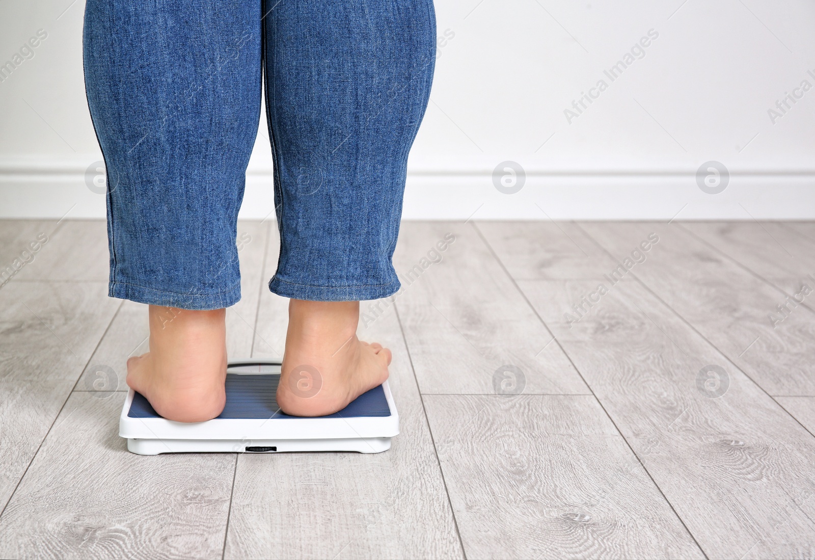 Photo of Overweight woman using scales indoors