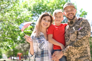 Photo of Male soldier with his family outdoors. Military service