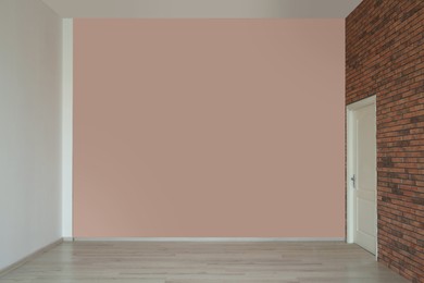 Photo of Empty room with different walls, white door and laminated floor