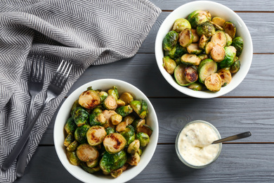 Delicious roasted Brussels sprouts served on grey wooden table, flat lay