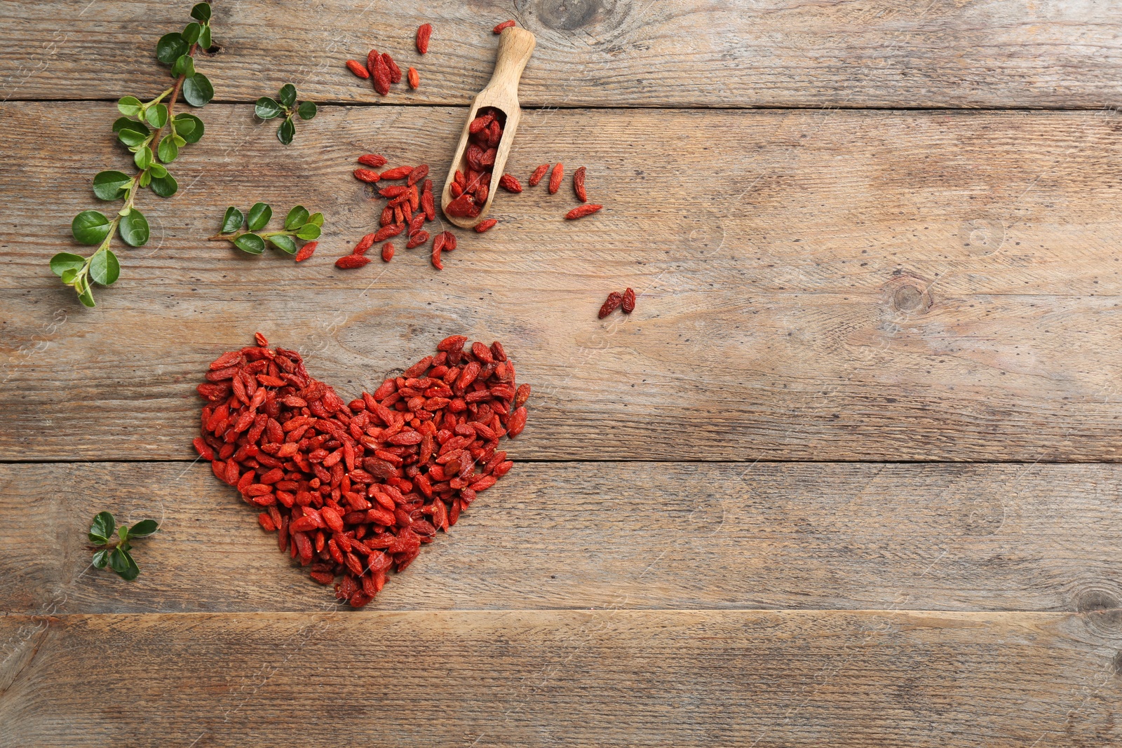 Photo of Flat lay composition with dried goji berries on wooden table, space for text. Healthy superfood