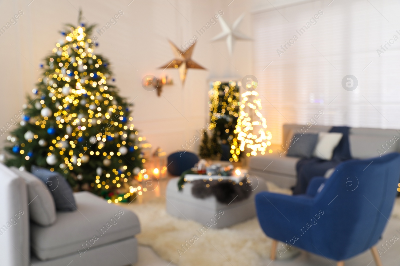 Photo of Blurred view of festively decorated room with Christmas tree and furniture