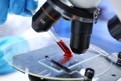 Photo of Laboratory worker running blood test using microscope, closeup. Research and analysis