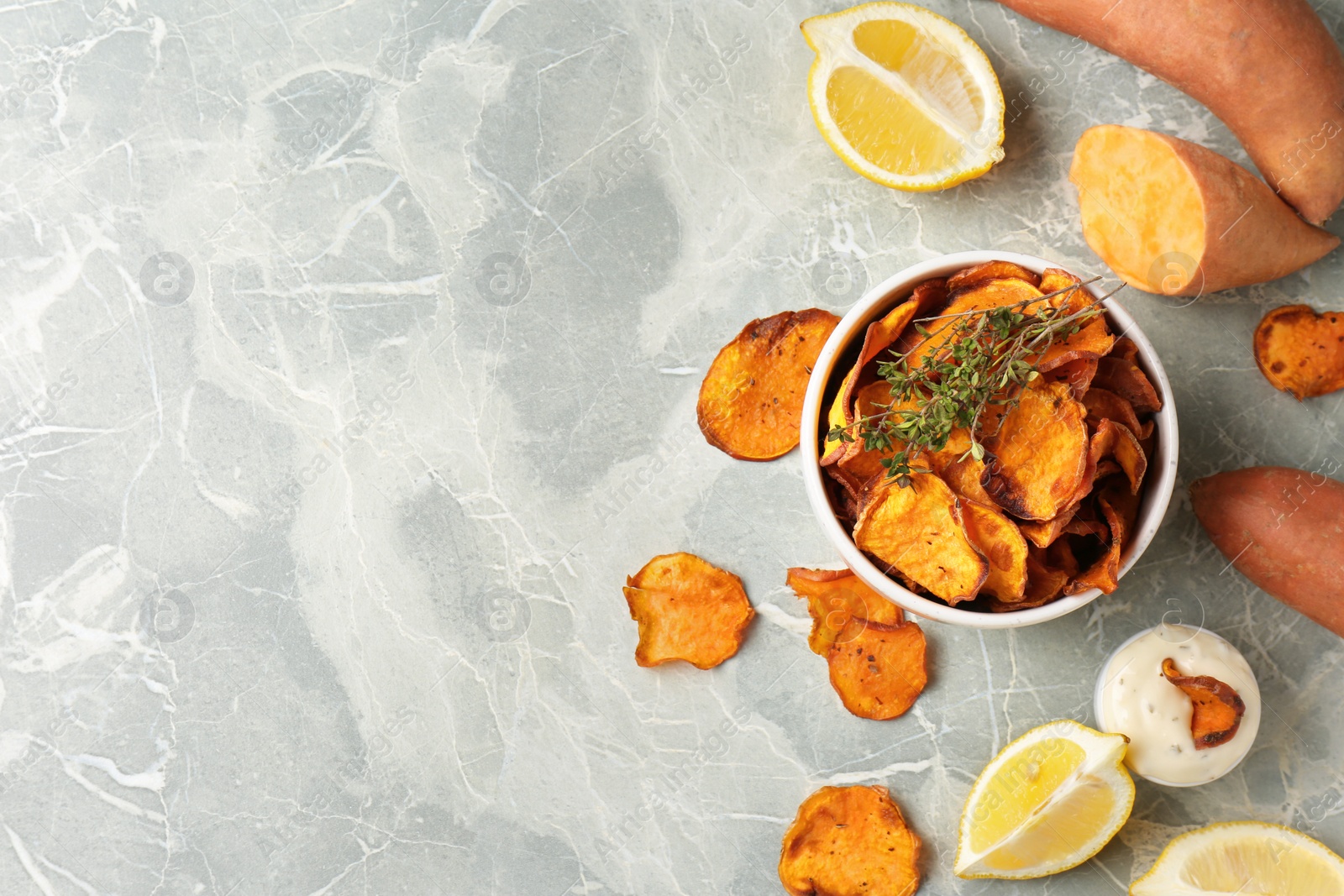 Photo of Flat lay composition with sweet potato chips on grey table. Space for text