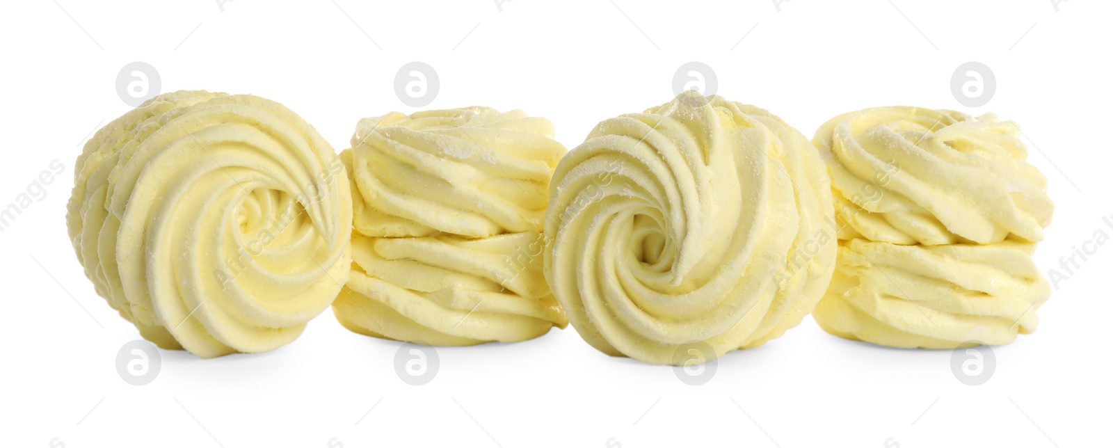 Photo of Many delicious yellow zephyrs on white background