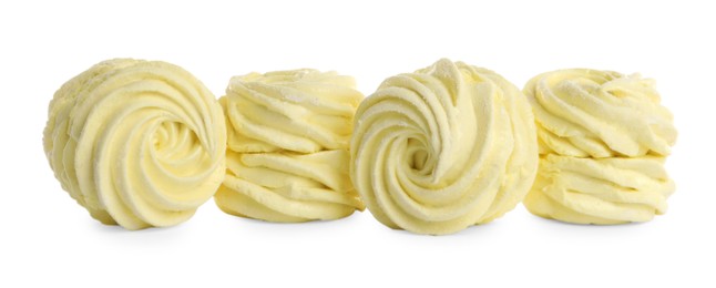Photo of Many delicious yellow zephyrs on white background
