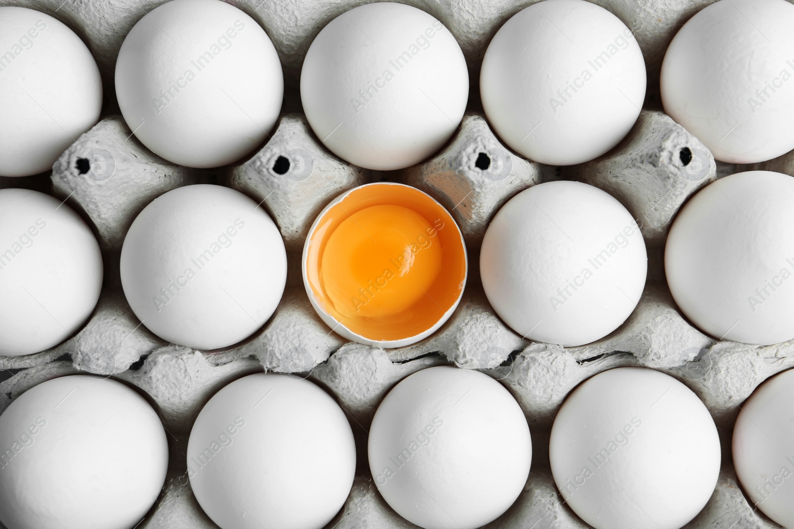 Photo of Many fresh raw chicken eggs in cartons as background, top view