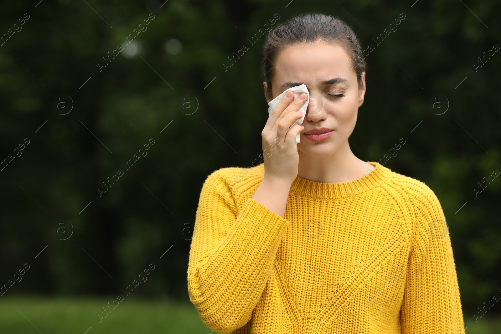 Photo of Woman suffering from seasonal spring allergy outdoors, space for text