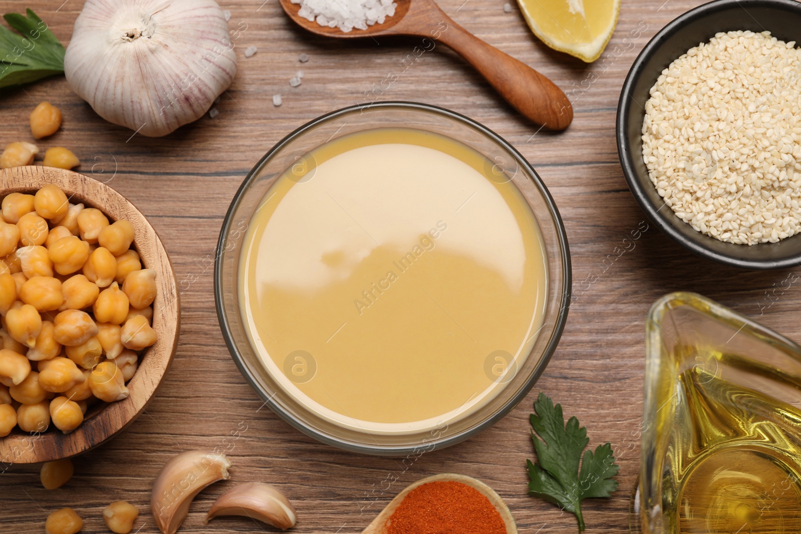 Photo of Different ingredients on wooden table, flat lay. Cooking delicious hummus