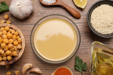 Photo of Different ingredients on wooden table, flat lay. Cooking delicious hummus