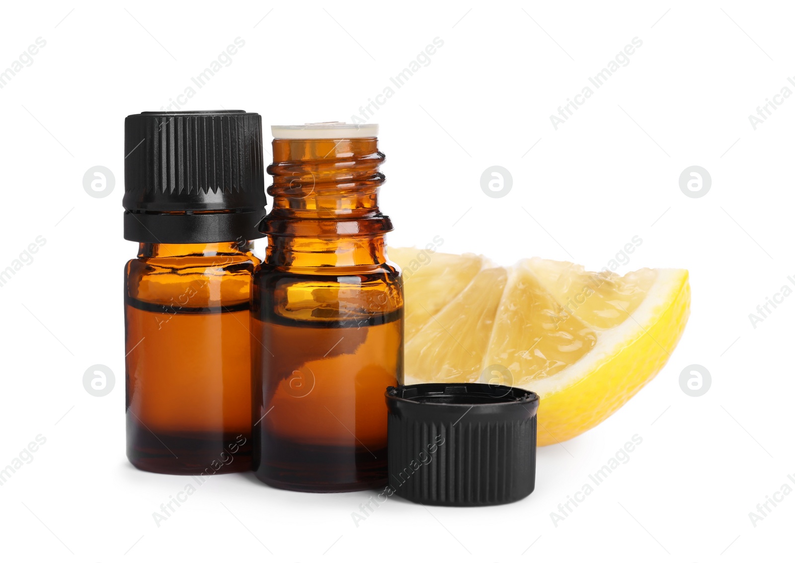 Photo of Bottles of citrus essential oil and cut fresh lemon isolated on white