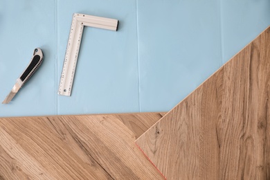 Photo of Installation of laminated wooden floor at home, top view
