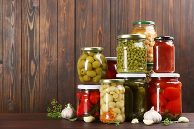 Jars of pickled vegetables on wooden table