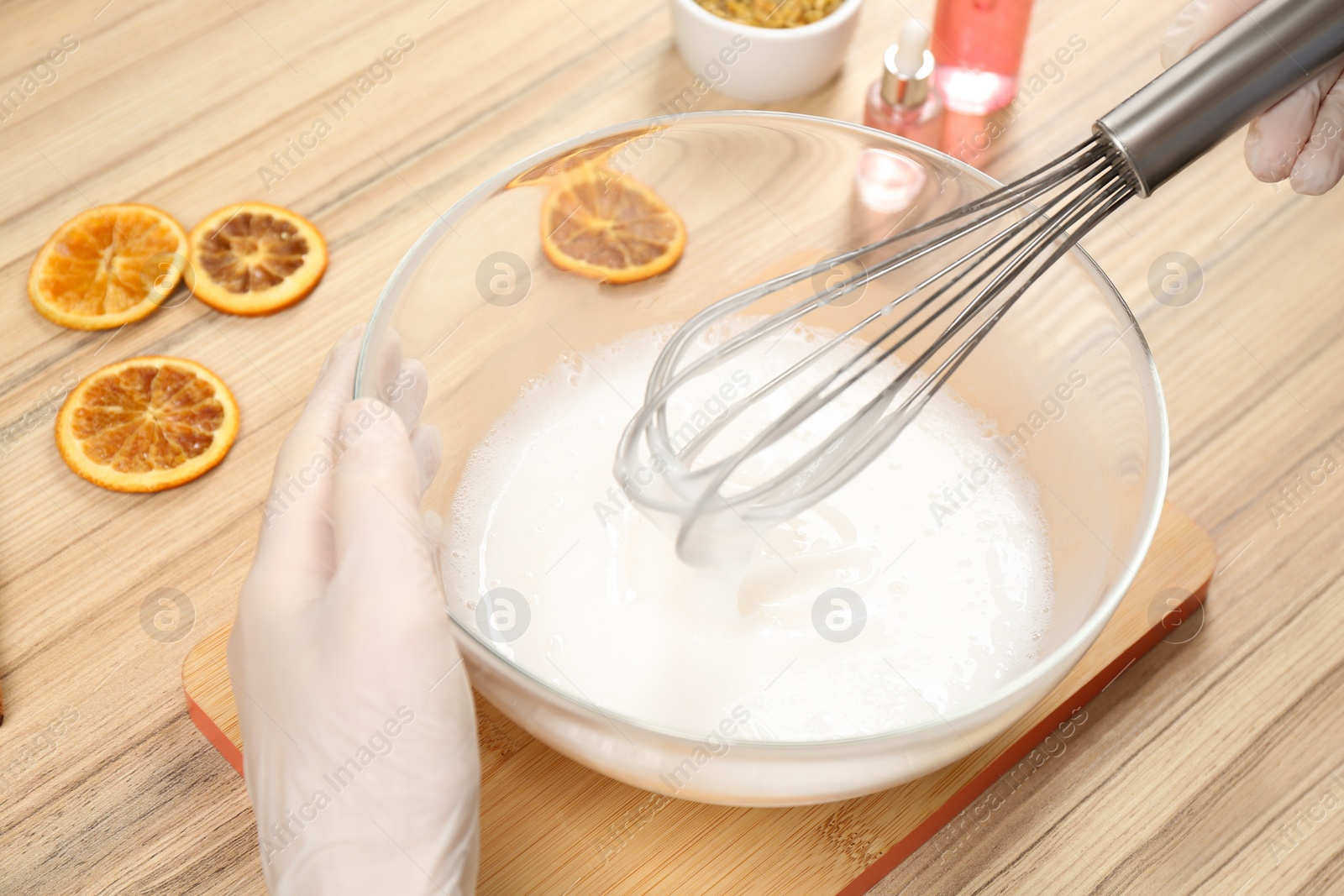 Photo of Woman making natural handmade soap at wooden table, closeup