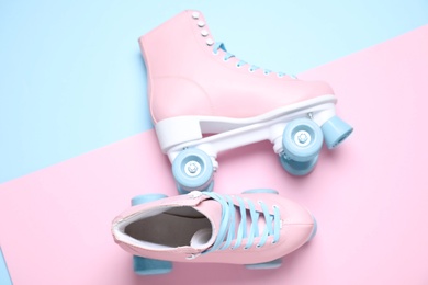 Pair of stylish quad roller skates on color background, flat lay